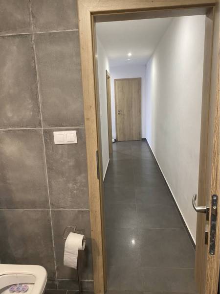 Na predaj: 3-izbový rodinný dom na predaj v obci Lesné Kračany - Toaleta v rodinnom dome s keramickými obkladmi a pohľad na chodbu.