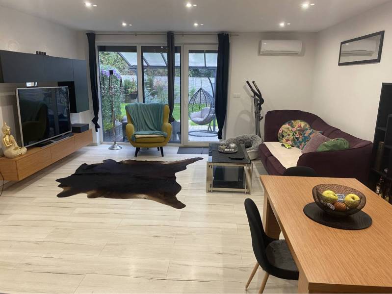 Na predaj: 3-izbový rodinný dom na predaj v obci Lesné Kračany - Obývacia izba v rodinnom dome s podlahou s dreveným dekorom a veľkorysým sedením.