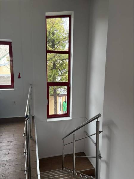 Prenájom nebytového priestoru na podnikateľské účely v CENTRE Dunajske - Schodisko s nerezovým zábradlím a podlahou s dreveným dekorom v budove.