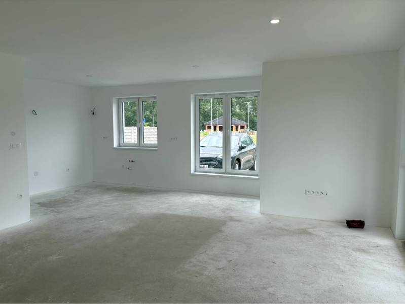 ☎️0917656551 - Prázdna miestnosť s viacerými oknami, bielymi stenami a betónovou podlahou v rodinnom dome.