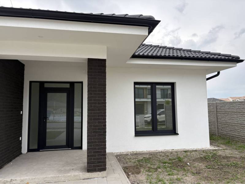 ☎️0917656551 - Rodinný dom na ulici FLORIDA VILLA PARK v Dunajskej Strede s čiernou strechou a verandou.