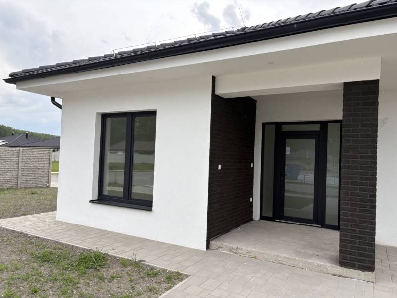 ☎️0917656551 - Rodinný dom v Dunajskej Strede na ulici FLORIDA VILLA PARK s tmavou fasádou a chodníkom.