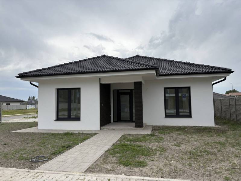 ☎️0917656551 - Rodinný dom na ulici FLORIDA VILLA PARK v Dunajskej Strede s tmavou strechou a trávnikom.