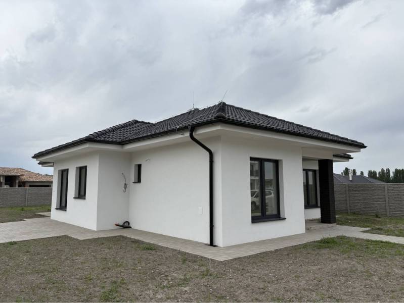 ☎️0917656551 - Rodinný dom na FLORIDA VILLA PARK v Dunajskej Strede s modernou strechou a bielou fasádou.