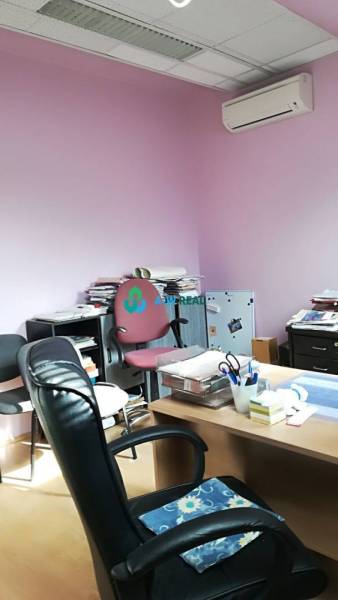 Kancelársky priestor s klimatizáciou na prenájom - Kancelária s ružovými stenami, stoličkami a stolom, na ulici neuvedené.