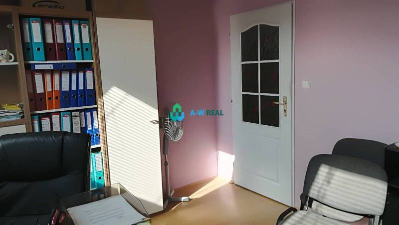 Kancelársky priestor s klimatizáciou na prenájom - Na obrázku sú kancelárie so stoličkami, ventilátorom a farebnými šanónmi v regáloch.