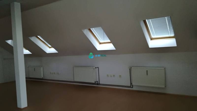 Kancelársky priestor na prenájom v Dunajskej Strede - Podkrovná miestnosť s strešnými oknami, radiátormi a zásuvkami v Kancelárie na ulici neuvedené.