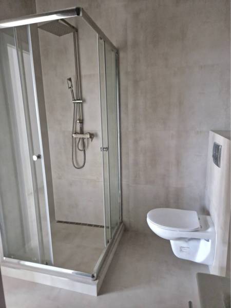 NOVOSTAVBA! Krásny, moderný a priestranný 3-izbový byt s veľkou logiou - Sprchový kút a závesné WC v kúpeľni 3-izbového bytu s jednoduchým dizajnom.