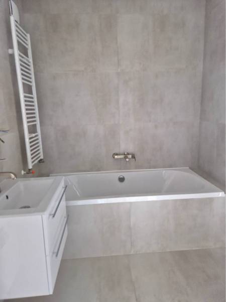 NOVOSTAVBA! Krásny, moderný a priestranný 3-izbový byt s veľkou logiou - Kúpeľňa v 3-izbovom byte s vkusnou vaňou a bielym umývadlom.