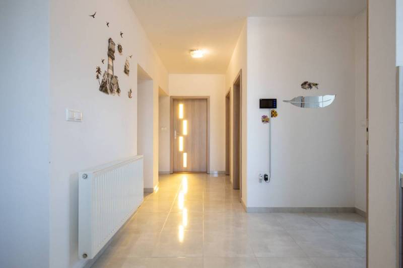 Dvojpodlažný rodinný dom s veľkým pozemkom na predaj v obci Jahodná - Chodba v rodinnom dome so svetlom, dekoráciami a svetlými dverami.