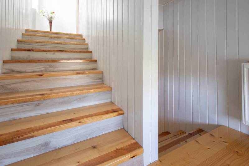 Dvojpodlažný rodinný dom s veľkým pozemkom na predaj v obci Jahodná - Drevené schodisko v Rodinnom dome na ulici, dekorácia s kvetmi na hornej podeste.