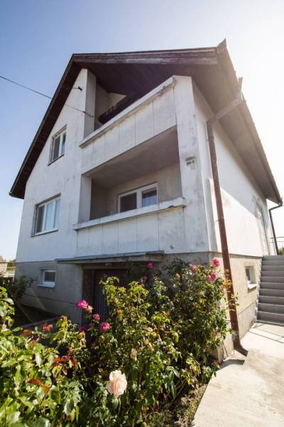 Dvojpodlažný rodinný dom s veľkým pozemkom na predaj v obci Jahodná - Rodinný dom so starším vonkajším vzhľadom, kvety na záhrade, na ulici neuvedená.