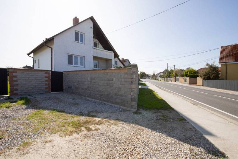 Dvojpodlažný rodinný dom s veľkým pozemkom na predaj v obci Jahodná - Rodinný dom, na ulici neuvedená, s kamenným plotom vedľa cesty a dvora.