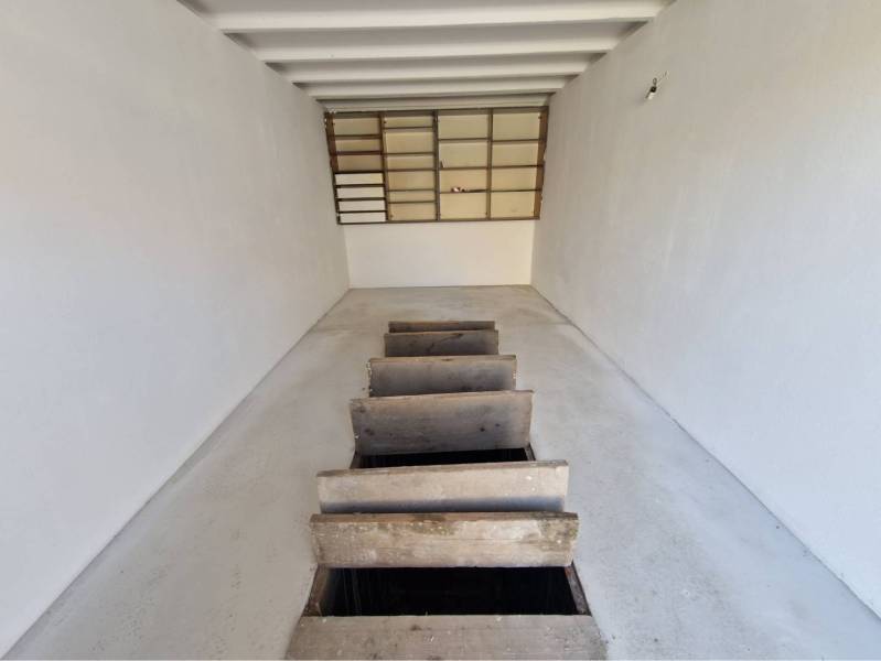 REZERVOVANÉ! Murovaná garáž - Garáže s bielymi stenami a dreveným poklopom na podlahe.