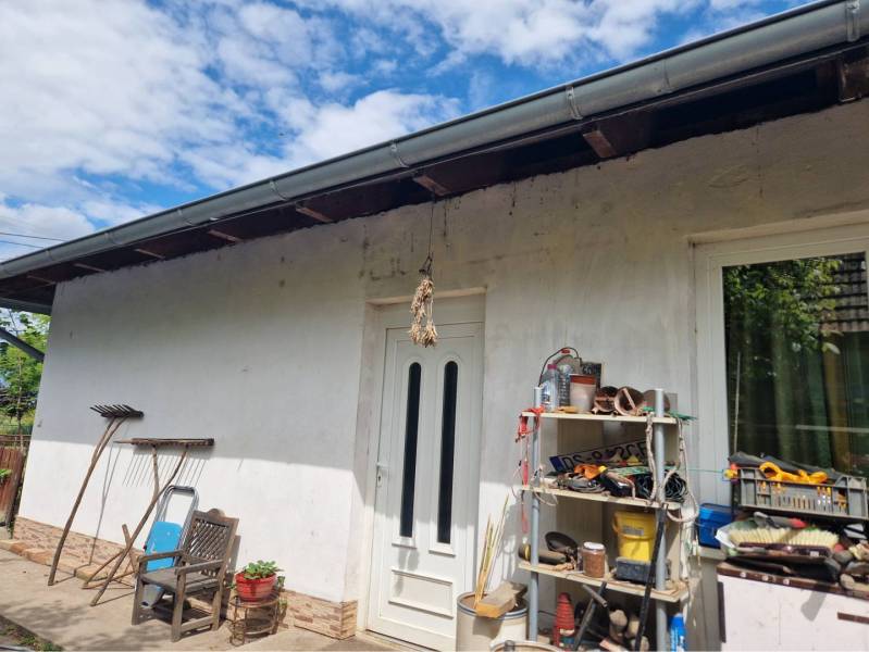 Na predaj 3 izbový rodinný dom s veľkým pozemkom - Rodinný dom v Dolnom Štáli s bielou fasádou, náradím a policou na dvore.