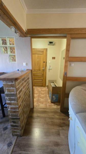 Na prenájom 3-izbový zariadený byt - Dunajská Streda - Interiér 3-izbového bytu s podlahou s dreveným dekorom a tehlovým barovým pultom.