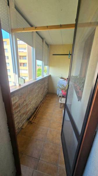 Na prenájom 3-izbový zariadený byt - Dunajská Streda - Zasklený balkón s tehlovým obkladom v 3-izbovom byte, kvetináče na drevenej konštrukcii.