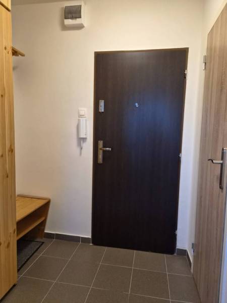 REZERVOVANÉ! Zariadená garsónka po kompletnej rekonštrukcii - Vstupná chodba Rekreačného apartmánu s tmavými dverami a dlažbou.