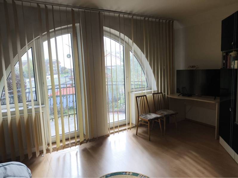 EXKLUZÍVNE LEN U NÁS! - Veľký rodinný dom - Dunajská Streda - Izba v rodinnom dome s oblúkovými oknami, vertikálnymi žalúziami a podlahou s dreveným dekorom.