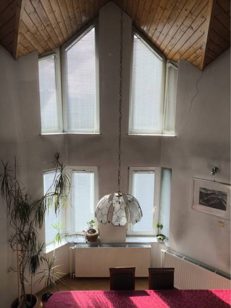 EXKLUZÍVNE LEN U NÁS! - Veľký rodinný dom - Dunajská Streda - V jedálni rodinného domu so šikmým dreveným stropom sú veľké okná a závesná lampa.