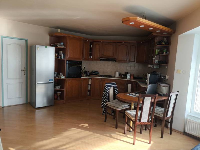 EXKLUZÍVNE LEN U NÁS! - Veľký rodinný dom - Dunajská Streda - Kuchyňa s drevenými skrinkami, jedálenským stolom a podlahou s dreveným dekorom v rodinnom dome.