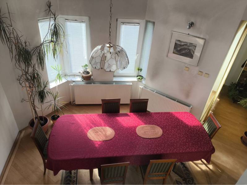 EXKLUZÍVNE LEN U NÁS! - Veľký rodinný dom - Dunajská Streda - Jedáleň v rodinnom dome s červeným obrusom a podlahou s dreveným dekorom.