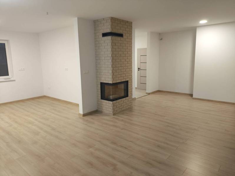 Rezervované / 4-izbový rodinný dom v obci Michal na Ostrove - Obývacia izba v rodinnom dome s krbom a podlahou s dreveným dekorom.