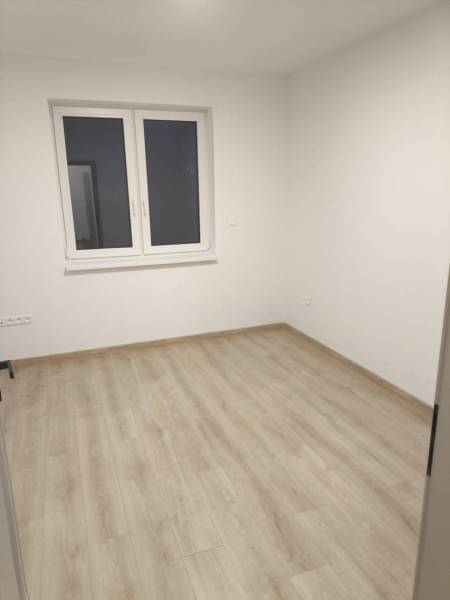 Rezervované / 4-izbový rodinný dom v obci Michal na Ostrove - Izba v rodinnom dome s podlahou s dreveným dekorom a veľkým oknom.