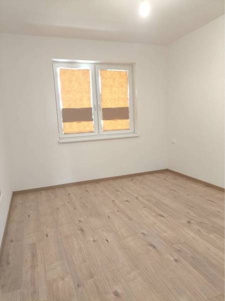 Predané - 4izbový rodinný dom (dvojdom) v obci Horná Potôň! - Prázdna miestnosť v rodinnom dome s podlahou s dreveným dekorom a oknom.