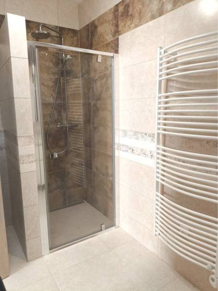 Predané - 4izbový rodinný dom (dvojdom) v obci Horná Potôň! - Sprchový kút s keramickými obkladmi a bielym radiátorom v kúpeľni rodinného domu.