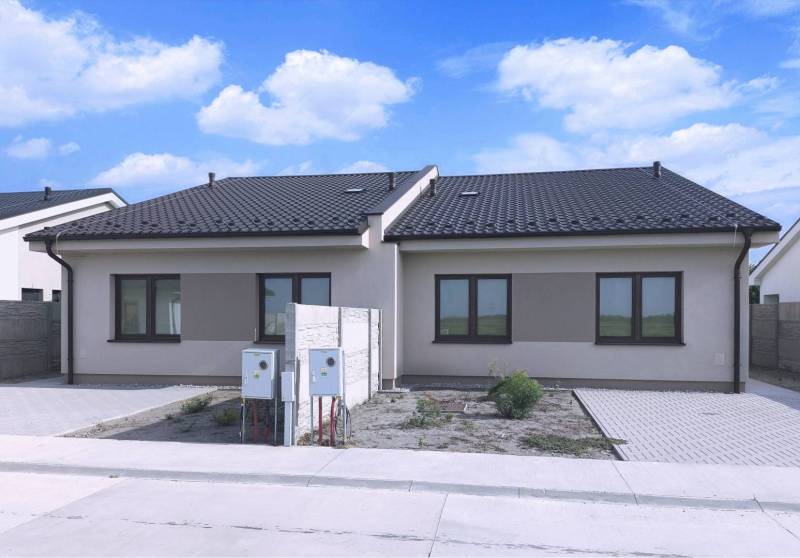 Predané - 4izbový rodinný dom (dvojdom) v obci Horná Potôň! - Dom v Hornej Potôni s tmavou strechou, dvomi oknami a priľahlou príjazdovou cestou.