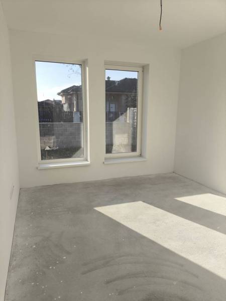 4 izbový rodinný  dom v obci Michal na Ostrove! - Prázdna miestnosť s veľkými oknami, bielymi stenami, betónovou podlahou v rodinnom dome.