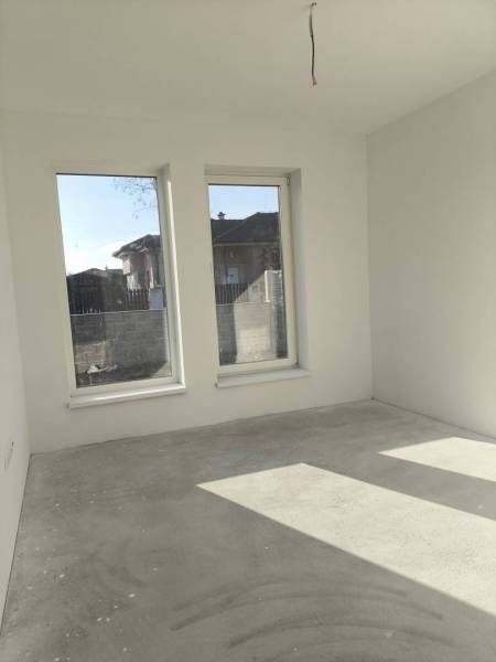 4 izbový rodinný  dom v obci Michal na Ostrove! - Rodinný dom s betónovou podlahou, bielymi stenami a veľkými oknami bez dekorácií.