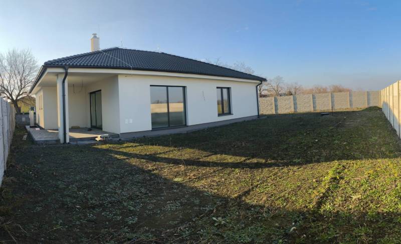 4 izbový rodinný  dom v obci Michal na Ostrove! - Rodinný dom v Michale na Ostrove s upravenou záhradou, plotom a šikmou strechou.