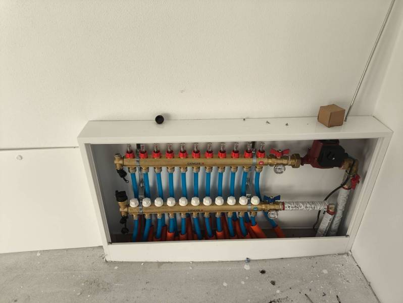 4 izbový rodinný  dom v obci Michal na Ostrove! - Rozdeľovač podlahového kúrenia v rodinnom dome s bielou stenou a podlahou.