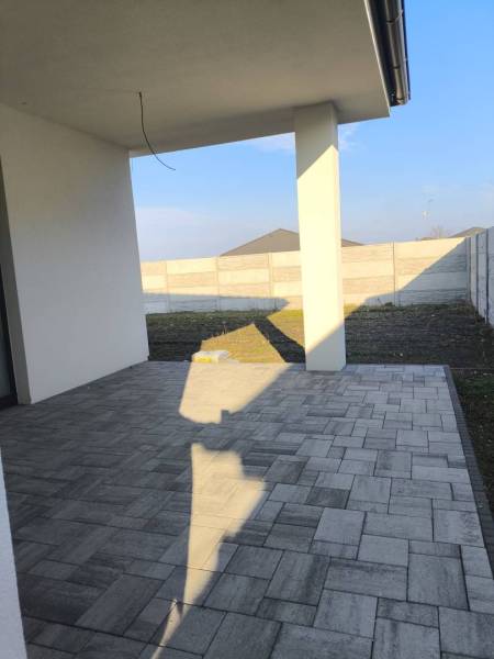 4 izbový rodinný  dom v obci Michal na Ostrove! - Terasa rodinného domu v Michale na Ostrove s dlažbou a výhľadom na dvor.