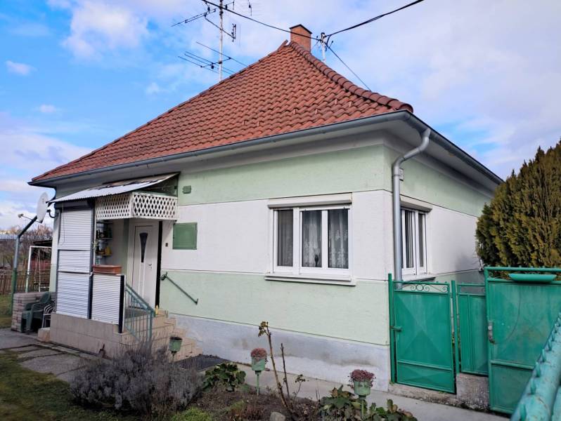Ponúkame Vám na predaj rodinný dom v obci Horná Potôň - Rodinný dom v Hornej Potôni s červenou strechou a zelenou bránou.