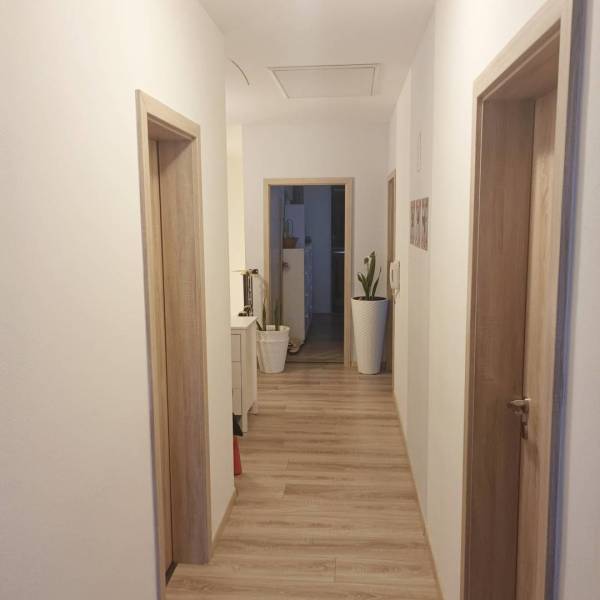 ☎️0904/842-727 Štýlové bývanie - 3izbový byt – Horný Bar - Chodba v 3-izbovom byte s podlahou s dreveným dekorom a bielymi stenami.