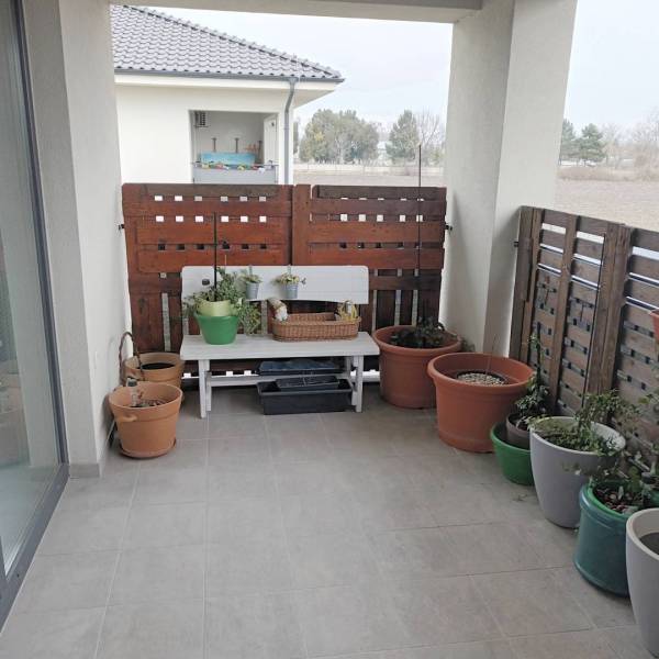 ☎️0904/842-727 Štýlové bývanie - 3izbový byt – Horný Bar - V 3-izbovom byte je balkón s kvetmi a drevenou zástenou.