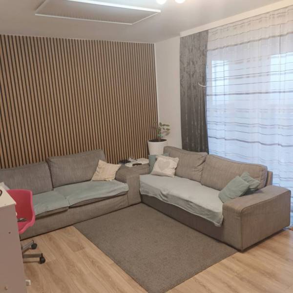 ☎️0904/842-727 Štýlové bývanie - 3izbový byt – Horný Bar - Obývacia izba v 3-izbovom byte s podlahou s dreveným dekorom a pohodlnou sedačkou.