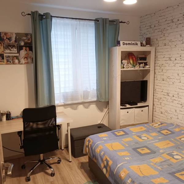 ☎️0904/842-727 Štýlové bývanie - 3izbový byt – Horný Bar - Izba v 3-izbovom byte s písacím stolom, posteľou a televízorom. Podlaha s dreveným dekorom.
