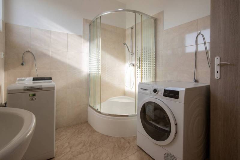 Znížená cena za 4 izbový rodinný dom v obci Jahodná - Kúpeľňa v rodinnom dome so sprchovým kútom, práčkou a sušičkou v interiéri.