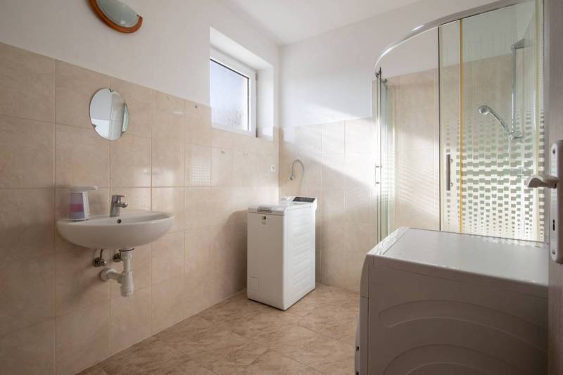 Znížená cena za 4 izbový rodinný dom v obci Jahodná - Kúpeľňa v rodinnom dome, s práčkou, sprchou a umývadlom, svetlé obklady.