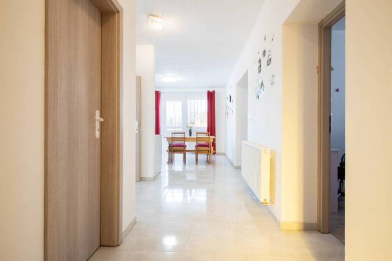 Znížená cena za 4 izbový rodinný dom v obci Jahodná - Interiér rodinného domu so vstupnou chodbou, svetlými dverami a jedálenským stolom.