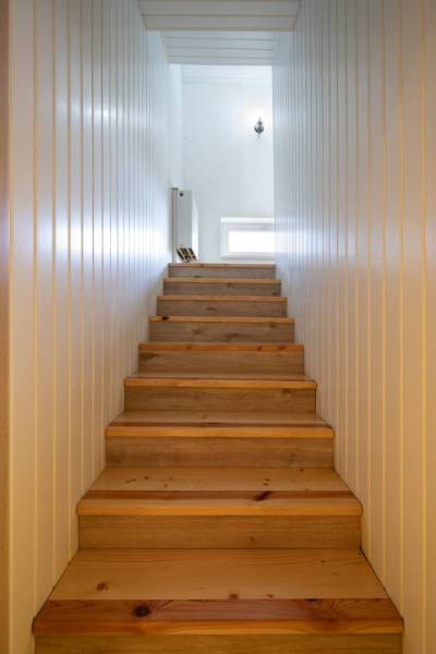 Znížená cena za 4 izbový rodinný dom v obci Jahodná - Drevené schody vedú na poschodie, svetlé steny rodinného domu osvetľuje okno.