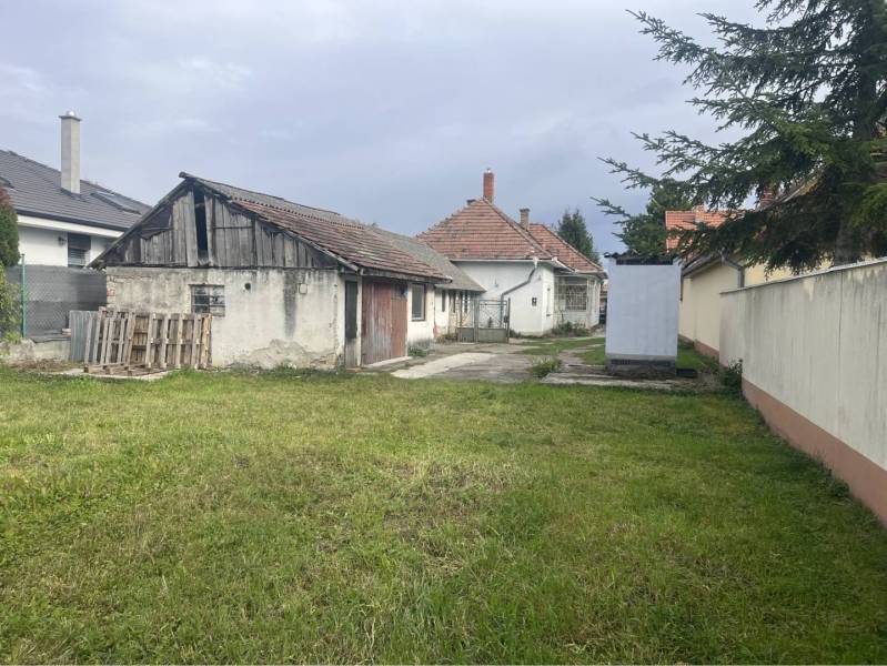 Znížená Cena!Na predaj rodinný dom vo Vrakúni, blízko Dunajskej Stredy - Zadný dvor rodinného domu vo Vrakúni s trávnikom a staršou prístavbou.