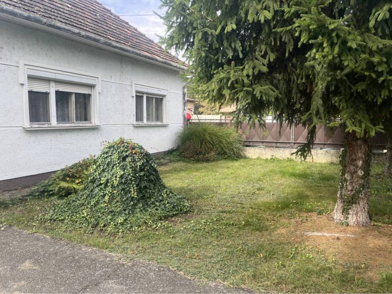 Znížená Cena!Na predaj rodinný dom vo Vrakúni, blízko Dunajskej Stredy - Rodinný dom vo Vrakúni obklopený zeleným trávnikom a stromami, vedľa asfaltového chodníka.