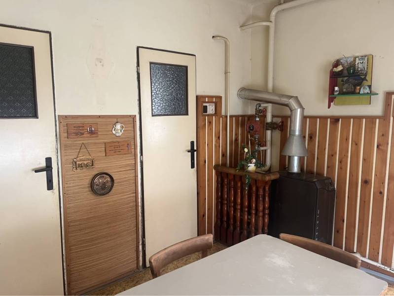 Znížená Cena!Na predaj rodinný dom vo Vrakúni, blízko Dunajskej Stredy - Interiér rodinného domu s pecou a dreveným obkladom na stene.