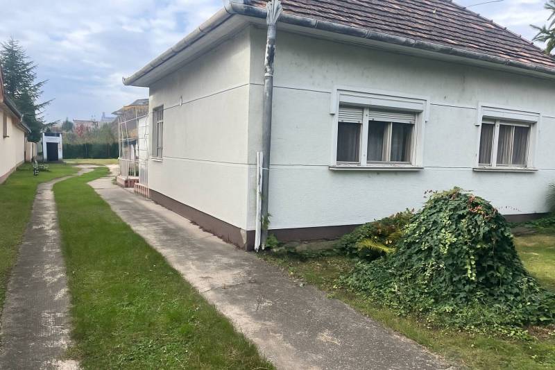 Znížená Cena!Na predaj rodinný dom vo Vrakúni, blízko Dunajskej Stredy - Rodinný dom vo Vrakúni s upravenou záhradou, chodníkom a bielou fasádou.