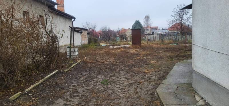 Na predaj starší rodinný dom v obci Ohrady - Záhrada rodinného domu v obci Ohrady, s neudržiavanou vegetáciou a nepoškodenými chodníkmi.